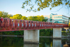 Red metal bridge with "INDIANA UNIVERSITY SOUTH BEND" on one side.